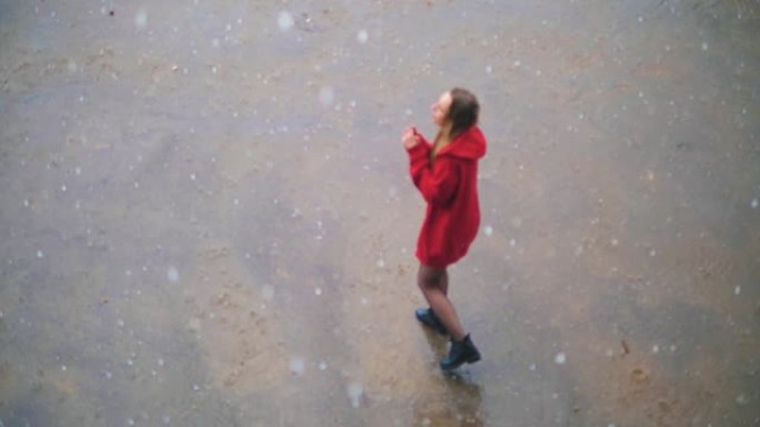 年轻美丽的悲伤女孩在雨中走在沥青上哭泣，尖叫，痛苦。