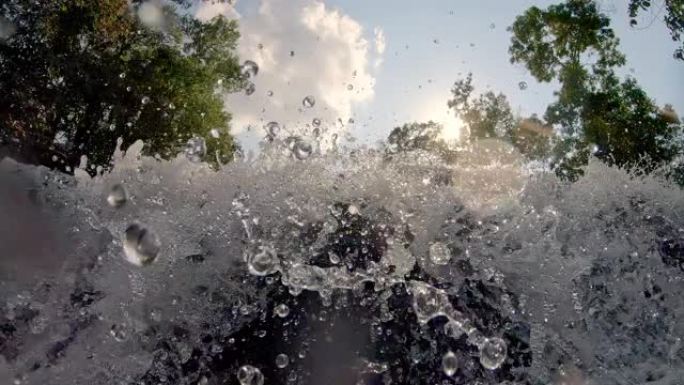 森林树木和水在前景中通过相机喷涌而出