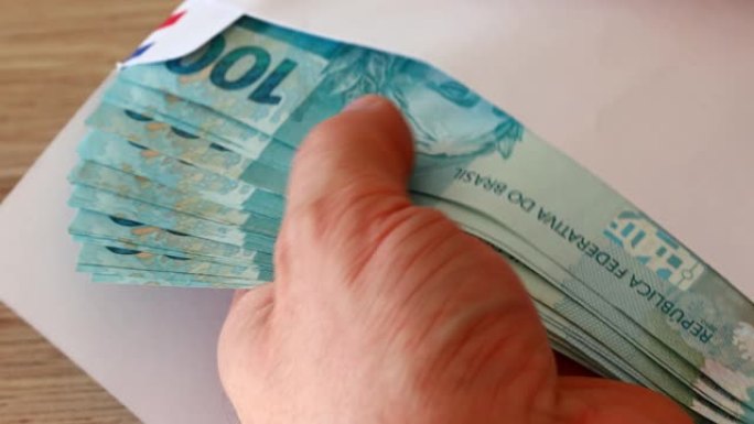 信封里的一捆巴西钱，一百张真的钞票，数量很大。贪污贿赂的概念