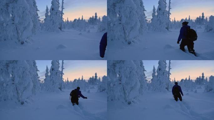 在拉普兰地区，一个背着背包的男人沿着膝盖深雪行走。-宽镜头