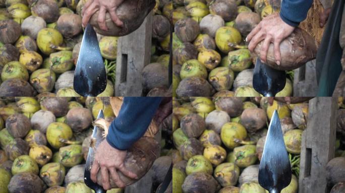 工人用旧锋利的刀打开椰子壳，剥开椰子壳。