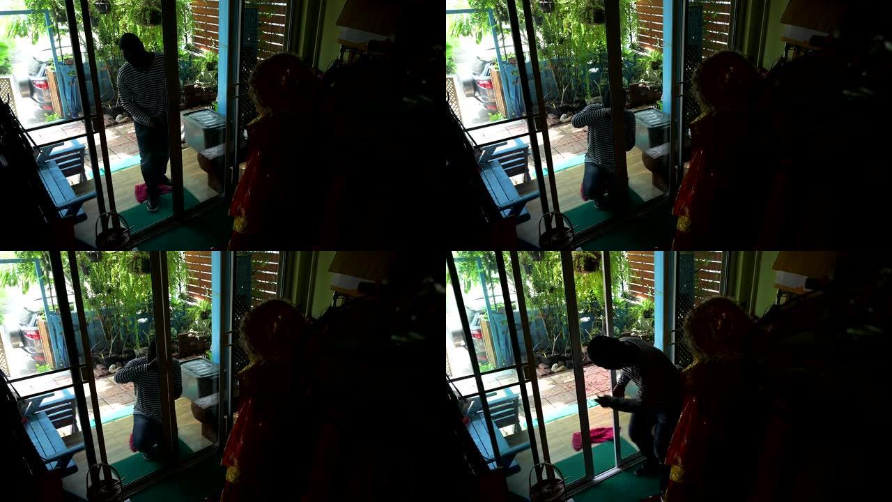 小偷试图打破玻璃门并搬进房子。