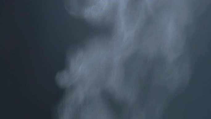 在黑暗的背景下，蒸汽从沸腾的锅中流出的特写镜头。