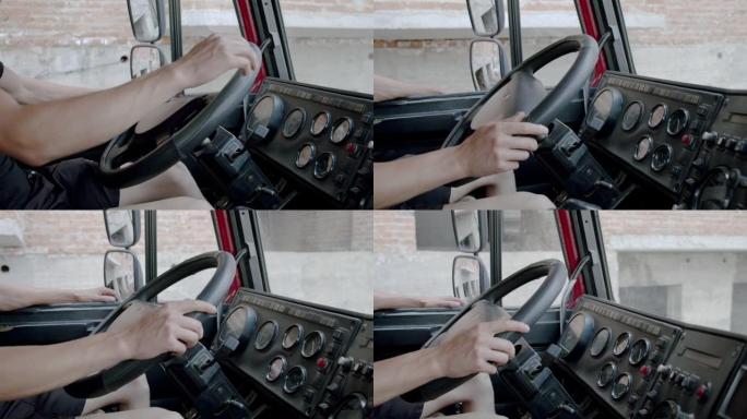 无法辨认的人把手放在方向盘上，从卡车驾驶室驾驶卡车。慢动作特写
