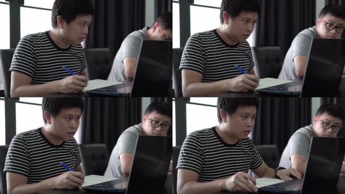 亚洲男子在家用笔记本电脑在线学习。