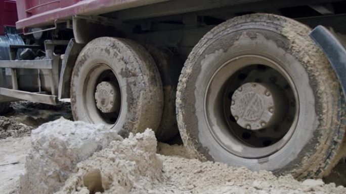 卡车的车轮在建筑工地穿过沼泽。特写