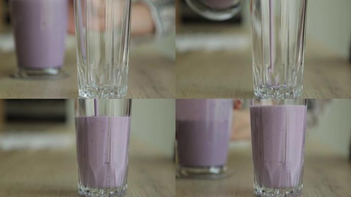 冰沙从上面混合在慢动作中。在白色背景下使用水果草莓，香蕉和酸奶。