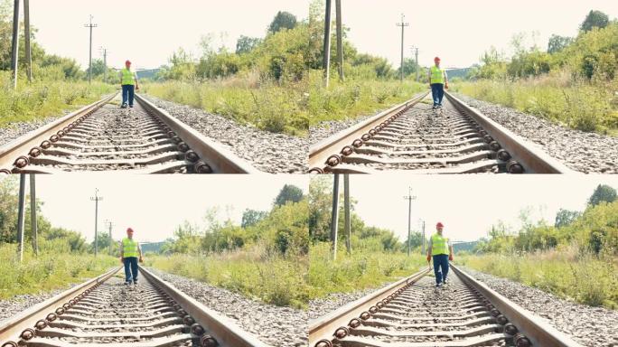 高级铁路工人在铁路上的制服步行远观，用锤子拍摄相机