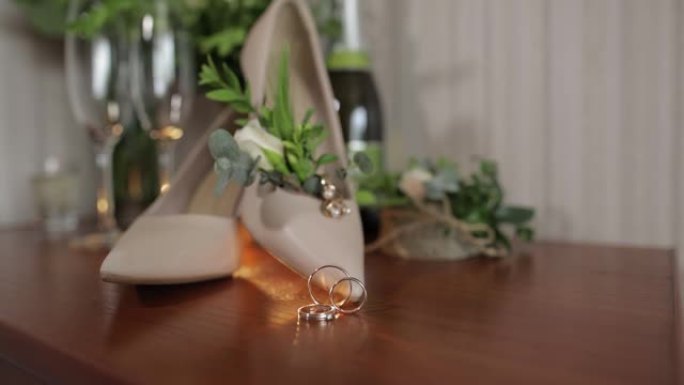 结婚戒指、花束、香槟、耳环和新娘鞋。新娘配件