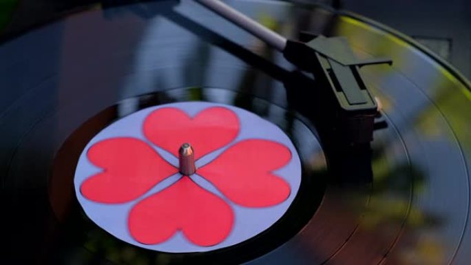 DJ转盘上红心旋转的黑色乙烯基唱片。古董唱机。60年代、70年代、80年代、90年代的打针唱片流行音