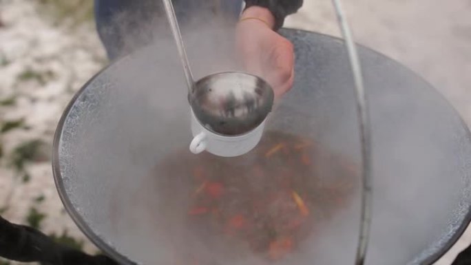 在露天的大锅中用羊肉煮汤的过程。