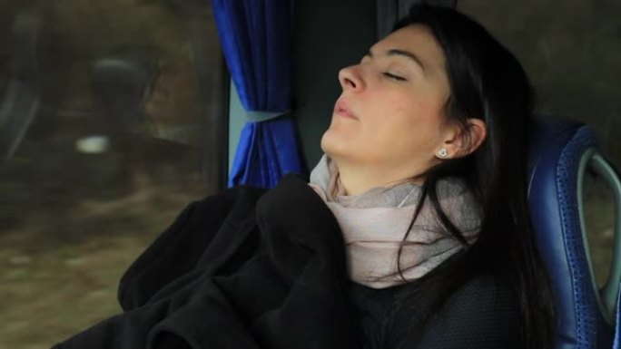 坦率的现实生活中的女人在乘公共汽车旅行时睡着了。女孩在公路旅行时睡觉