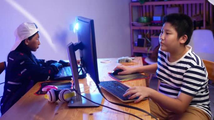 两个孩子在家里晚上用led灯一起玩网络游戏。男孩和女孩玩充分的情感，生活方式的概念。