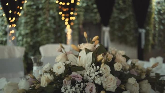 婚礼餐厅装饰灯光。婚礼餐桌装饰配有天然鲜花花束，为家庭盛宴。