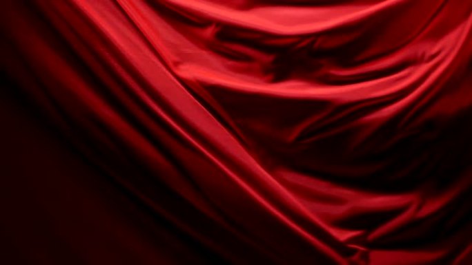在戏剧性的灯光下，黑色背景上浅红色织物的移动褶皱别致而优雅的质感。慢动作200 FPS