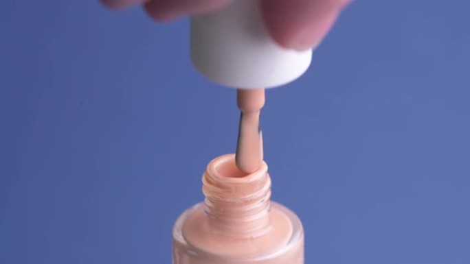 打开一罐浅粉色指甲油。美容院，指甲延伸。