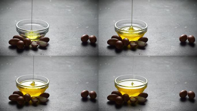 摩洛哥坚果油倒入玻璃碗中，玻璃碗中有摩洛哥坚果籽，背景在阳光下。基于摩洛哥坚果油的化妆品概念。复制空