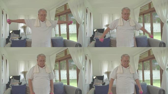 亚洲爷爷在家里的客厅里举重锻炼。健康的概念。