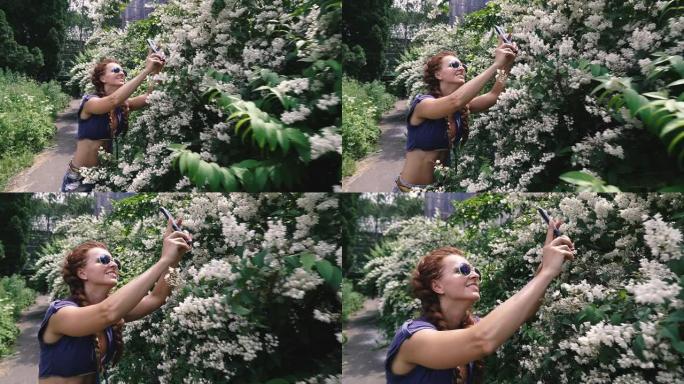 智能手机。一个年轻的女人在智能手机上拿花。