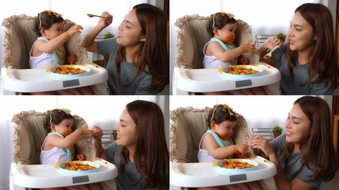 亚洲保姆喜欢取笑小女孩，不要给可怜的蹒跚学步的女婴喂食物，孩子想从保姆那里拿勺子吃东西。可爱的蹒跚学