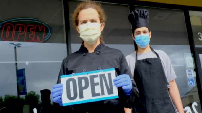 厨师快餐店和成熟的女老板假扮戴着面具拿着开放标志