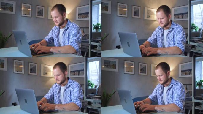 男人正在工作打字在黑暗的夜晚在家庭办公室使用笔记本电脑。社交媒体facebook浏览。