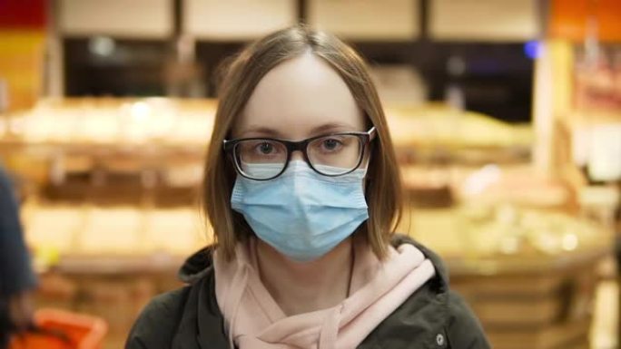 戴着防护医用口罩和眼镜的女人。肖像。超市慢动作特写