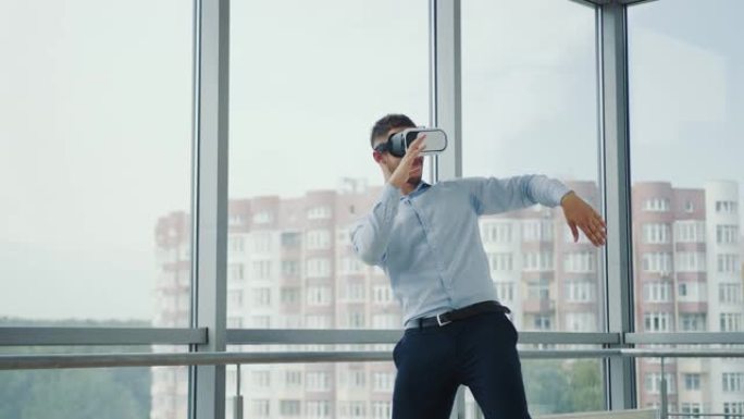 坐在办公室办公桌前的近距离年轻人使用增强现实眼镜从事各个领域的商业项目。虚拟现实中的工作