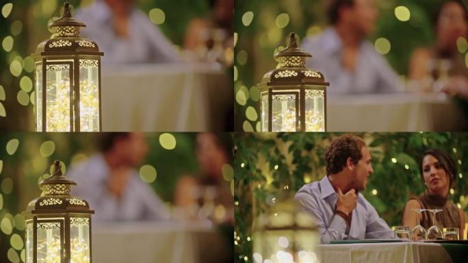四个人，两对夫妇在浪漫的美食晚餐或午餐期间愉快地交谈和吃饭。闪亮的灯光。中等镜头。翁布里亚的朋友意大