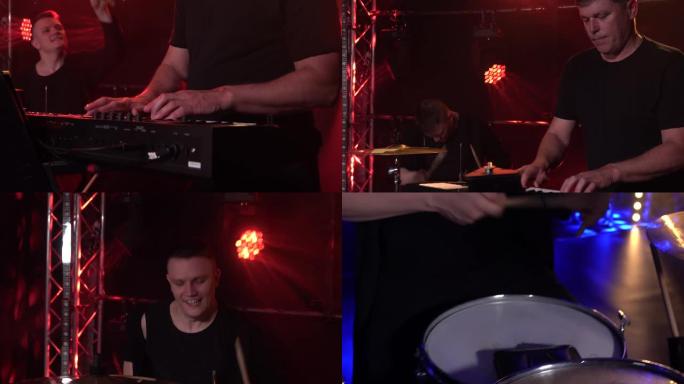 音乐家在黑暗的工作室里用烟雾和霓虹灯演奏钢琴合成器键盘和鼓。动态霓虹灯照明效果。表演声乐和音乐乐队。