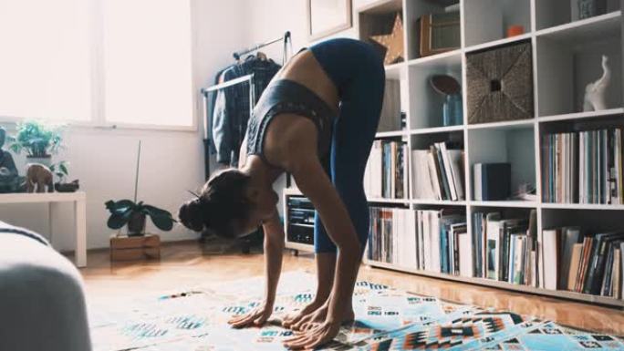 女人在家练习瑜伽，做站立向前弯曲运动