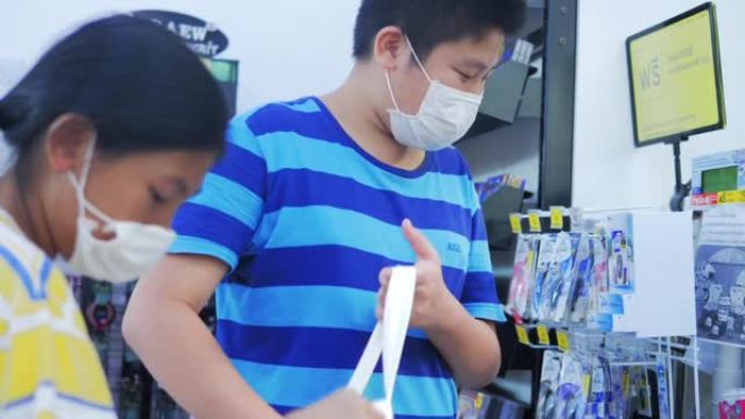 亚洲男孩和女孩在新型冠状病毒肺炎期间在便利店囤积食物。