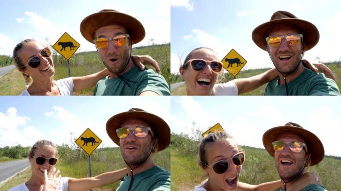 年轻夫妇在佛罗里达黑豹警告标志附近空荡荡的高速公路上自拍
