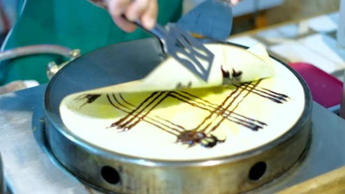 厨师用香蕉山药和巧克力做牛奶可丽饼就完成了。泰国街头美食。
