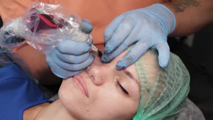 永久化妆师在女人的上眼睑上纹身