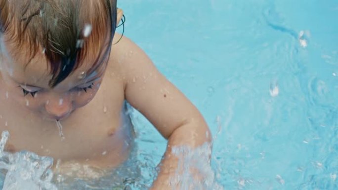 可爱的小孩在庭院的蓝色街道游泳池洗澡。快乐蹒跚学步的肖像，宝贝。孩子笑，泼水，笑。健康生活方式、家庭