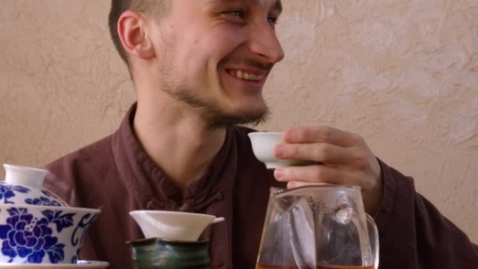 肖像快乐的人在茶道上大笑。微笑的茶师享受新鲜饮料。快乐的人在东方餐厅喝茶。