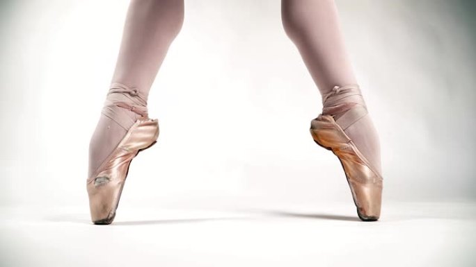 美丽的芭蕾舞脚尖头鞋站在芭蕾舞的姿势。白色背景上的芭蕾舞女演员。古典舞