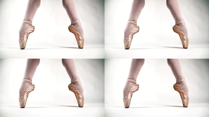 美丽的芭蕾舞脚尖头鞋站在芭蕾舞的姿势。白色背景上的芭蕾舞女演员。古典舞