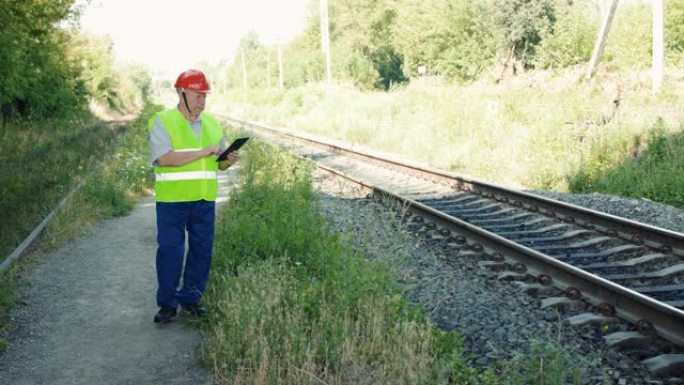 工程师在检查铁路的适用性时在平板电脑上固定数据