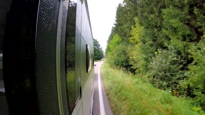 POV: 在乡村的巴伐利亚路上拖着大篷车的汽车