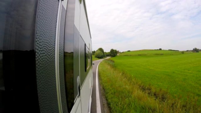 POV: 在乡村的巴伐利亚路上拖着大篷车的汽车