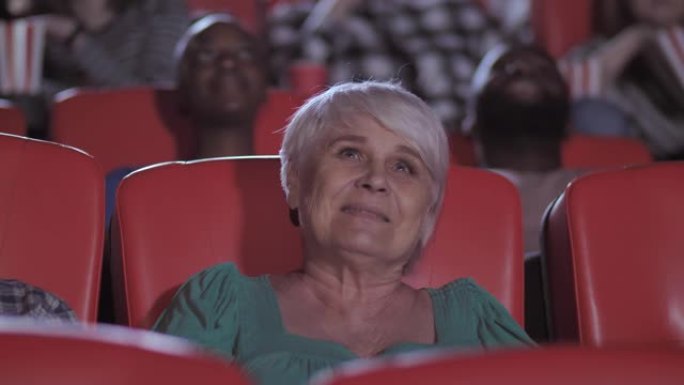 在电影院观看情节剧的老年妇女