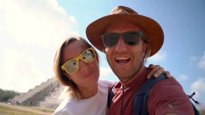 年轻夫妇在墨西哥古老的玛雅神庙前自拍，在度假时玩得很开心。两人在墨西哥拍摄自拍照