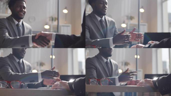 黑人商人握手并与同事交谈的特写镜头