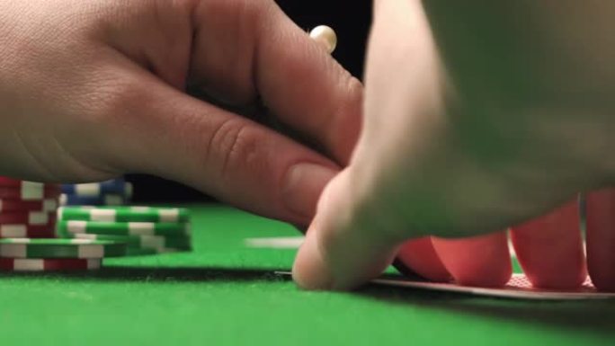 一名女扑克玩家检查她的手，有一双