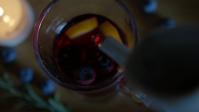 热热葡萄酒被倒入木质背景的爱尔兰咖啡杯中。