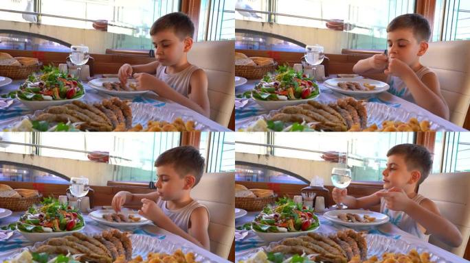 小男孩在餐馆吃鱼