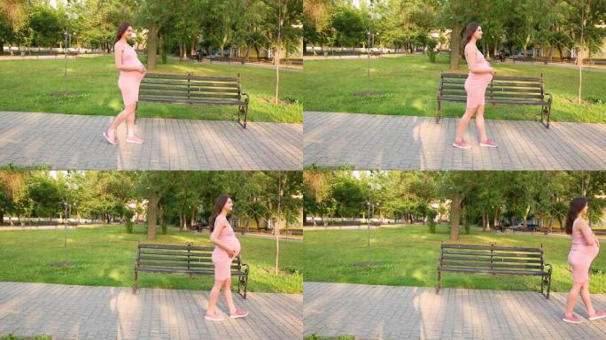 孕妇很高兴照顾她的孩子。年轻的准妈妈在街上抱着怀孕的肚子