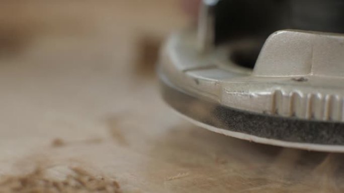 宏观。木匠使用手动电动铣刀工作。木工加工木板